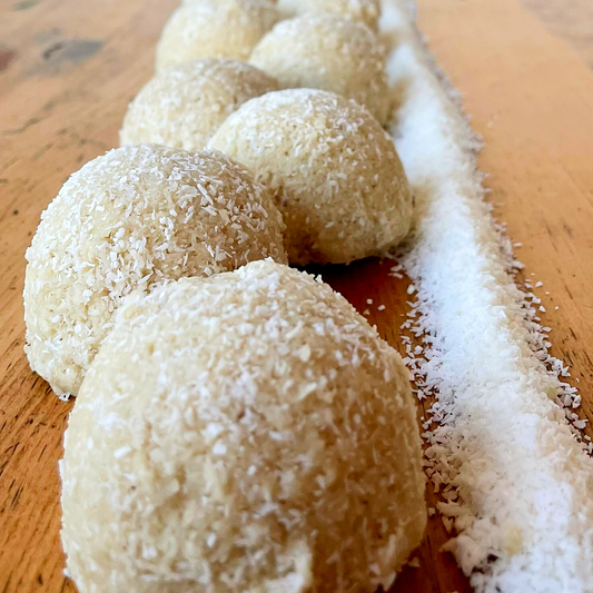 snow pop petite boule craquée à la noix coco bio avec une touche fleurie à l'eau de fleur d'oranger.  Ingrédients: noix de coco*, sirop d'érable*, tahiné, huile de noix de coco*, eau de fleur d'oranger, sel rose Boulangerie et pâttiserie à outremont montréal Vegan et sans Gluten