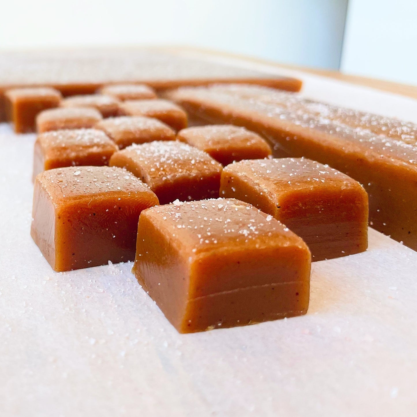 vanilla carmel dusted with salt at bakery and sweet shop in outremont Montréal. Caramel à la vanille salé dans boulangerie à outremont, montréal. caramel à la vanille Caramels irrésistible, uniques, qui fonde.   les caramels sont fait sans sirop de maïs et sont couper et emballer à la main avec d'emballages compostables.  ingrédients: crème, sucre*, miel, cassonade, beurre, café*, cardamome, sel rose de l'Himalaya. produits certifiés biologiques, les produits d'agriculture raisonnée. 